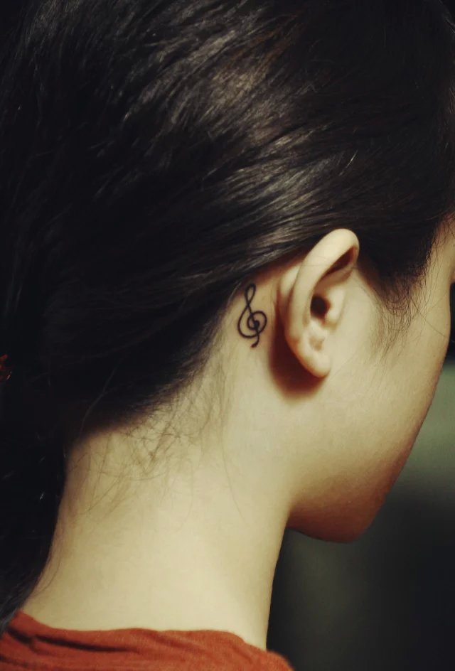 张小姐耳部后面的悦动音符纹身图案
