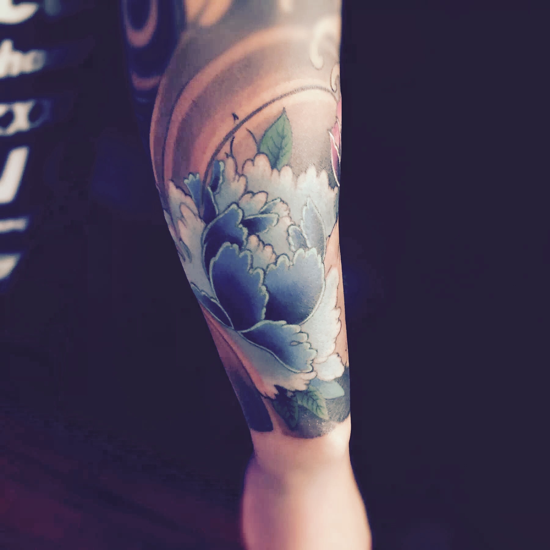 广州杨先生手臂上的蓝色牡丹纹身图案